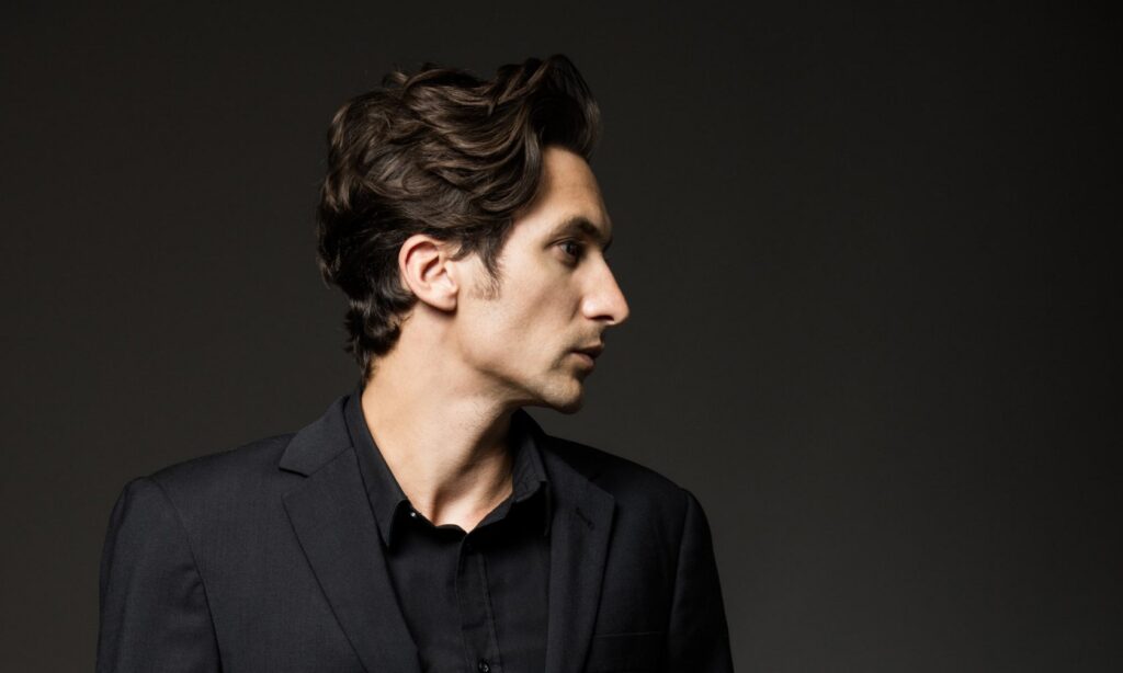 14 Fresh Haircut Ideas for Men with Curly Hair: Elevate Your Look with Texture and Style 11 Man with slicked back mid length curly hair